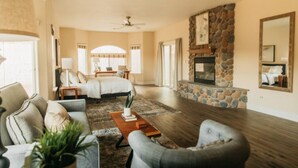 A spacious living room with a fireplace, a large bed, and a dining area. - Panoramic Lookout *Sierra Serenity* BBQ by CasaOso (Mariposa)