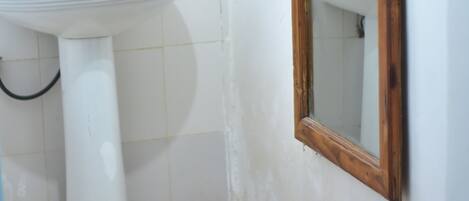 A bathroom with a white sink, a mirror, and a tiled floor.