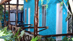 A row of blue buildings with white doors and windows, surrounded by lush greenery. - La Neisha hotel Nungwi (Nungwi)