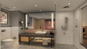 Un bany modern amb un mirall gran, un lavabo, un vàter i una dutxa.