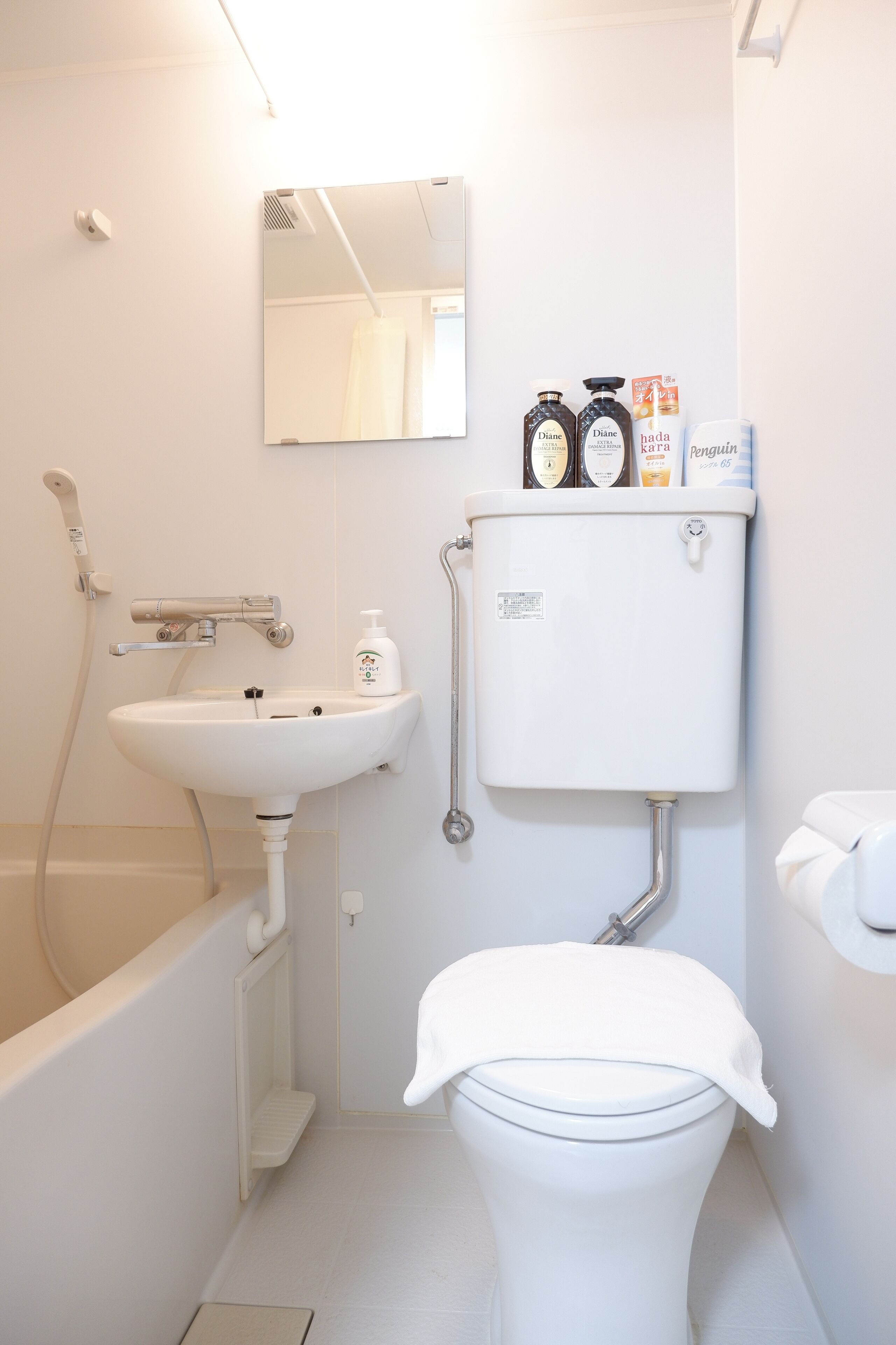 A bathroom with a toilet, sink, and shower.