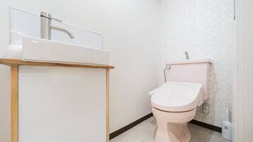 A bathroom with a white sink, a toilet, and a mirror.