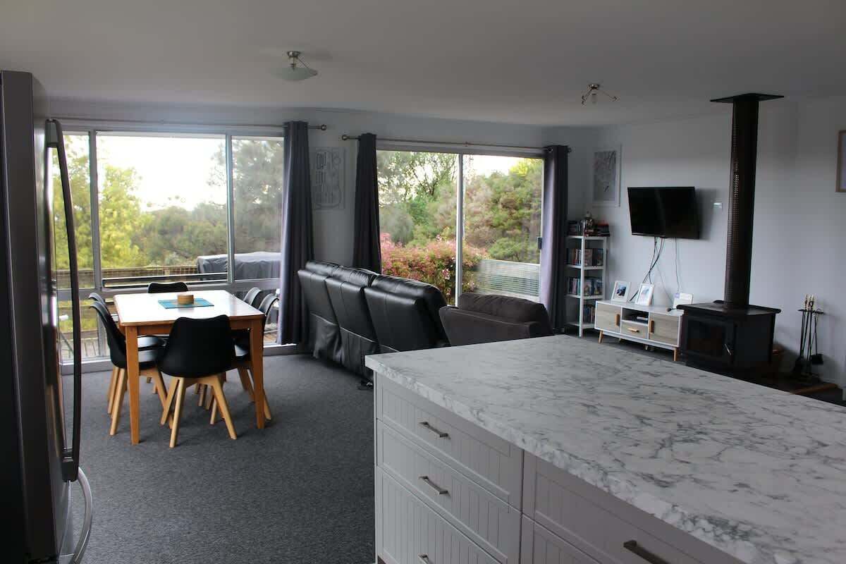 A modern room with a dining table, chairs, a sofa, a TV, and a fireplace.