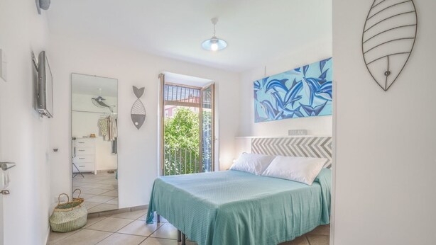 A bedroom with a bed, a window, a door, and a wall-mounted artwork. - 4 Bedrooms Apt in Sorrento Center | location&view (Sorrento)