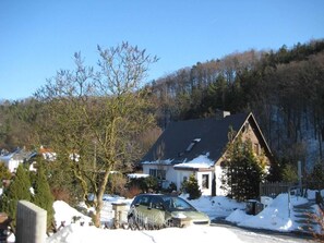Ett bostadsområde med hus, en bil och ett träd i förgrunden.