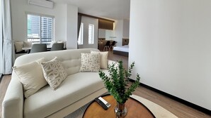 A modern living room with a sofa, a coffee table, and a potted plant. - WH Hotel 310  (Phnom Penh)