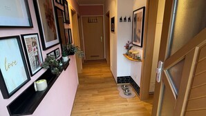 A hallway with framed pictures on the walls, a ceiling fan, and a door leading to another room. - Cozy apartment with conservatory near the safari park - dogs welcome (Verl)