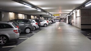 A parking garage with multiple rows of parked cars and directional arrows on the floor. - Aparthotel Autosole (Estepona)