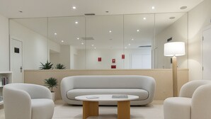 A modern living room with a sofa, two armchairs, a coffee table, and a floor lamp. - Aparthotel Autosole (Estepona)