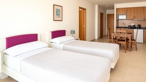 A hotel room with two beds, a kitchenette, and a dining area. - Aparthotel Autosole (Estepona)