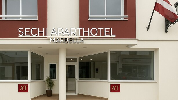 The exterior of the Sechi Aparthotel in Marbella, featuring a modern facade with large windows and a flag. - Aparthotel Autosole (Estepona)