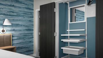 A modern bedroom with a bed, a nightstand, a lamp, a wardrobe with shelves, and a wall with a blue abstract pattern.