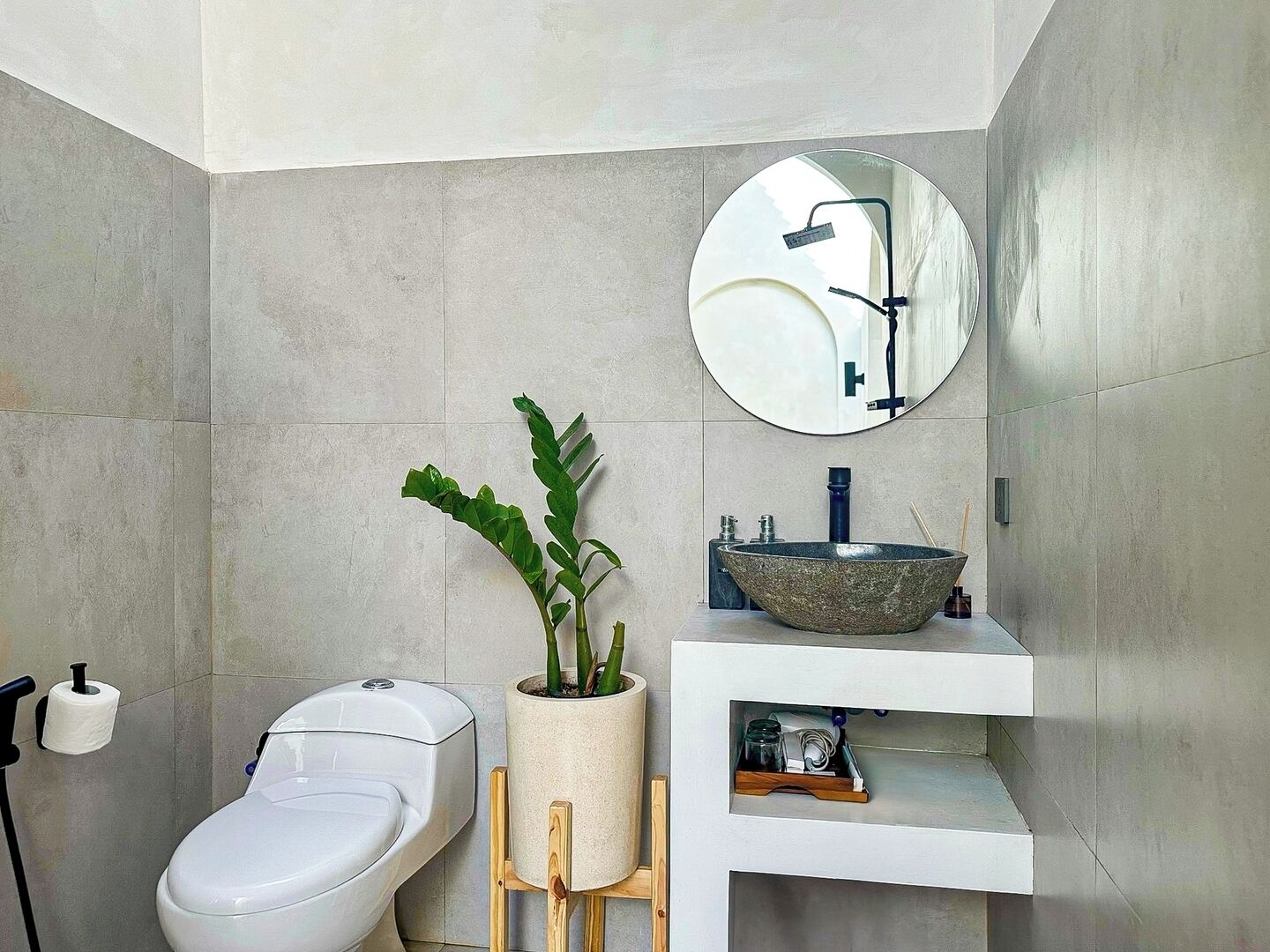 A modern bathroom with a toilet, sink, and shower.
