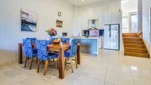A modern kitchen with white cabinets, a central island, and a stainless steel refrigerator. - StayAU 3BR Deluxe Family Loft Point Cook (Point Cook)