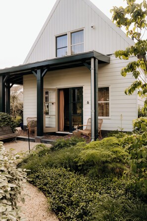 A modern house with a covered porch, a garden with various plants, and a bench. - De Durgerdam Amsterdam (Amsterdam)