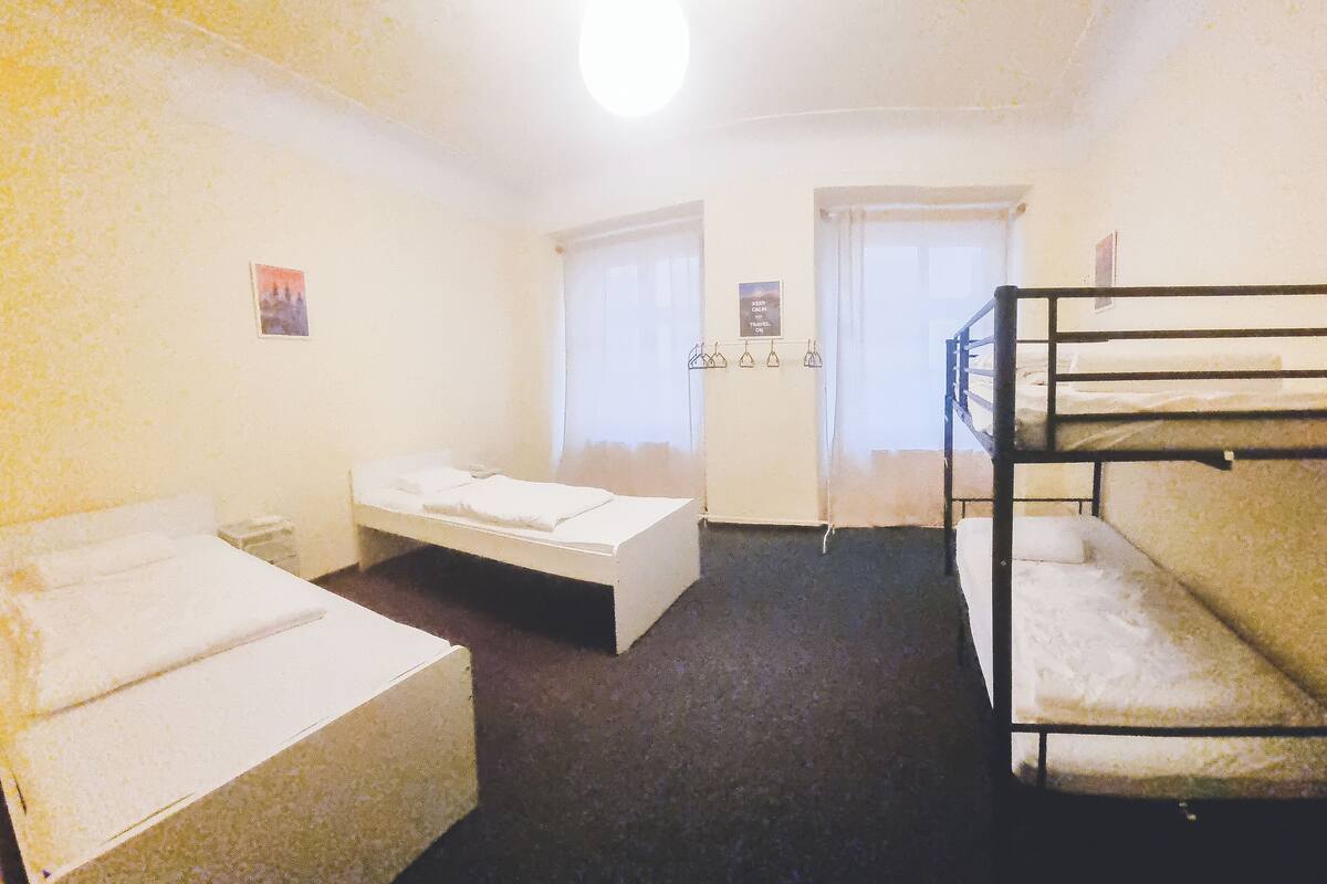 A room with bunk beds, a single bed, and a small table.
