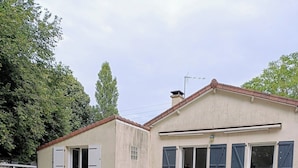 Un edificio de dos pisos con techo plano y un balcón.