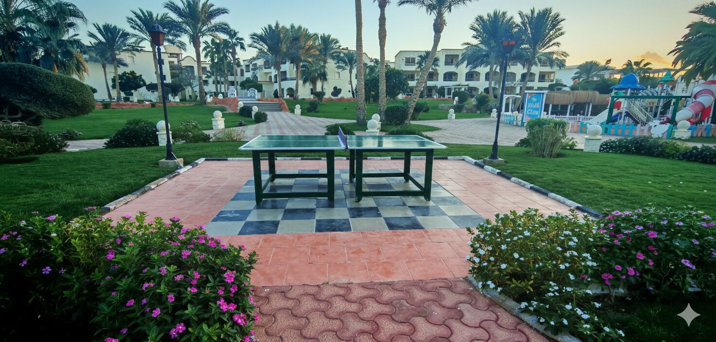 A checkered outdoor area with a table, surrounded by well-maintained gardens and palm trees.