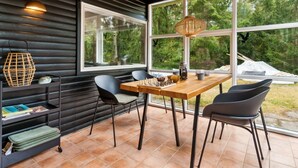 A modern interior with a wooden ceiling, large windows, and a chessboard on a table.