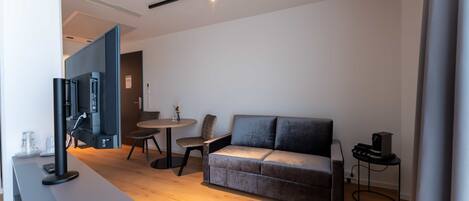 Un salon moderne avec un canapé gris, une table basse et un meuble pour la télévision.