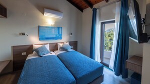 A bedroom with two beds, a wooden ceiling, an air conditioning unit, a painting, and a window with curtains. - Istros Villa III, Infinite Blue, Pool & Whirlpool (G37Q+HX Pithari, Greece)