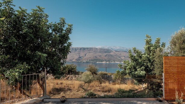 A terrace with two sun loungers, a view of a lake, and a mountainous landscape. - Istros Villa III, Infinite Blue, Pool & Whirlpool (G37Q+HX Pithari, Greece)