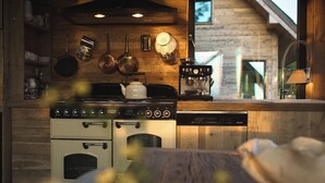 Una cocina con estufa, horno y máquina de café.