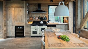Una cocina moderna con armarios de madera, una isla grande y una lámpara colgante.
