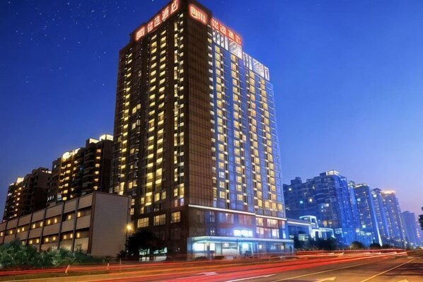 A high-rise hotel with multiple floors, illuminated windows, and a prominent signage at the top. - Ming Yi Hotel (Zhuzhou)