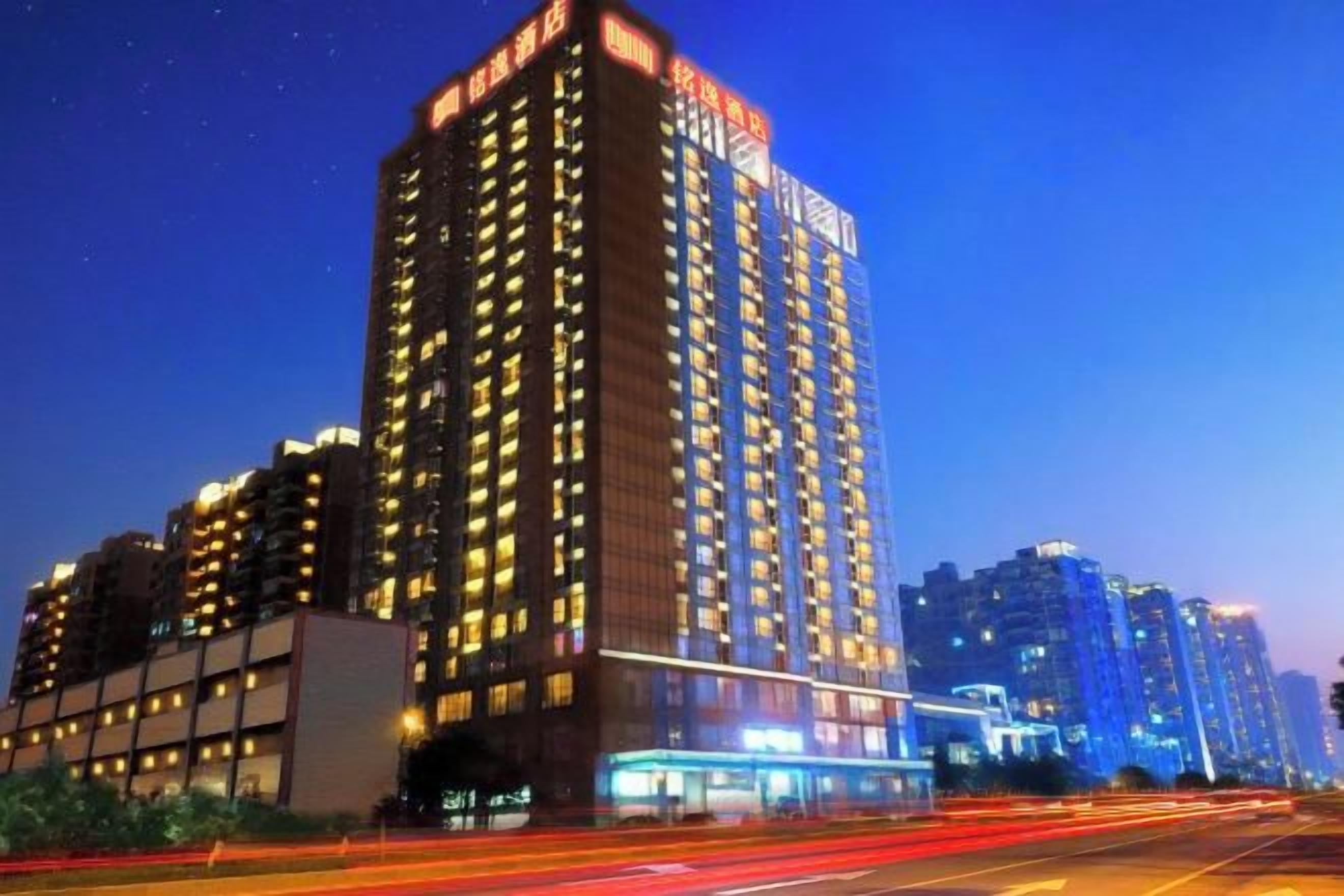 Een hoog gebouw met meerdere verdiepingen, vermoedelijk een hotel of appartementencomplex, met verlichte ramen die aangeven dat het bewoond is.