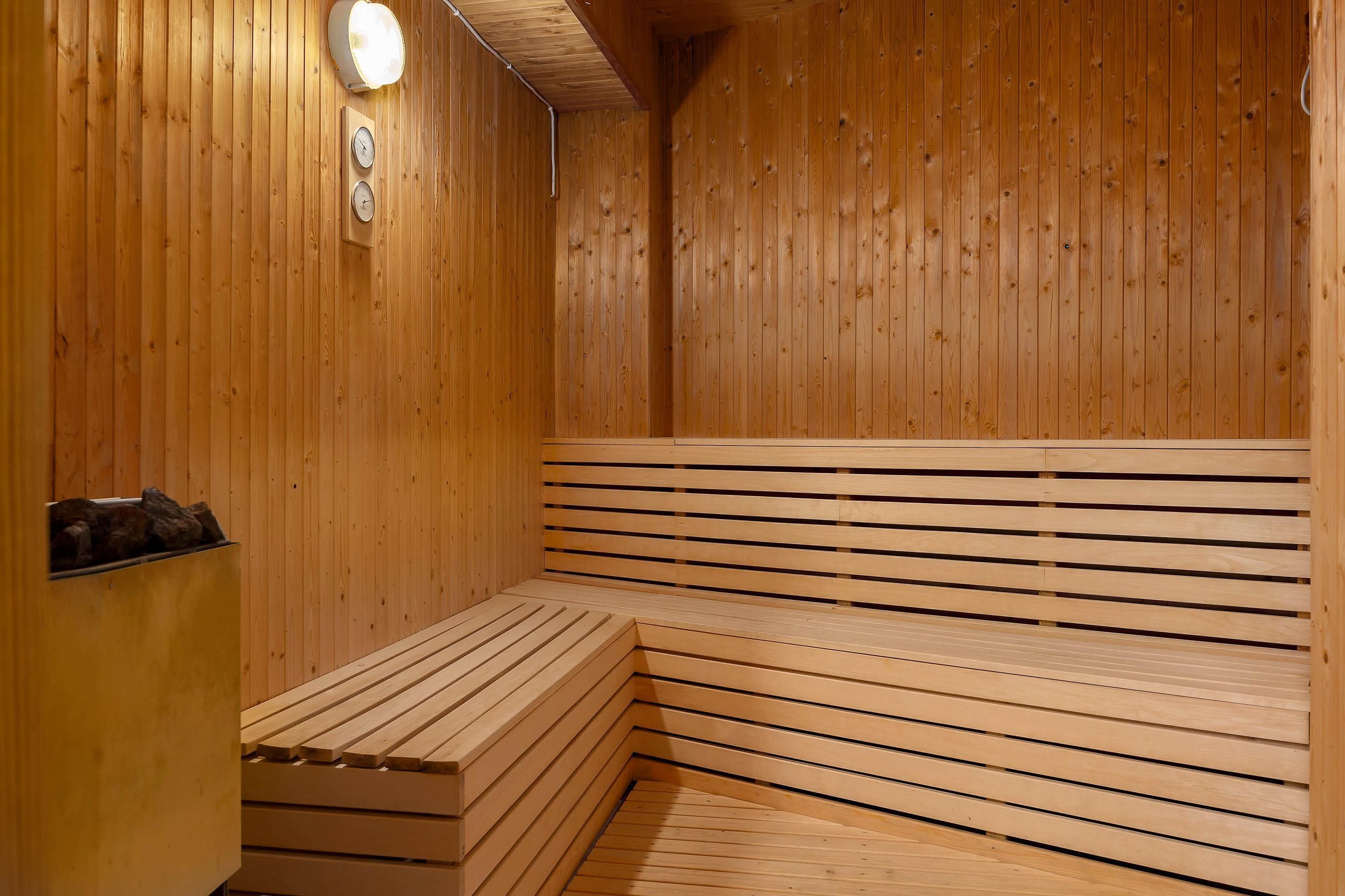 Un sauna avec des bancs en bois et une horloge fixée au mur.