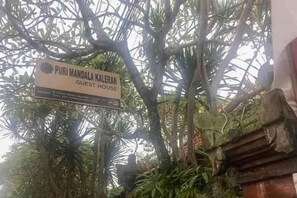A sign for 'Puri Mandala Kaleran Guest House' amidst tropical foliage. - Puri Mandala Kaleran (Bali)