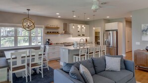 A modern kitchen with a central island, white cabinetry, and stainless steel appliances. - Big Pine Beach House (Crosslake)