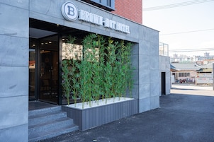 Das Hotel Brown Dot mit moderner Fassade, Glastür und vertikalem Garten
