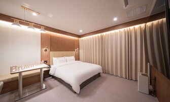 Ein modernes Hotelzimmer mit einem großen Bett, einem Nachttisch und einem Schreibtisch mit Spiegel.