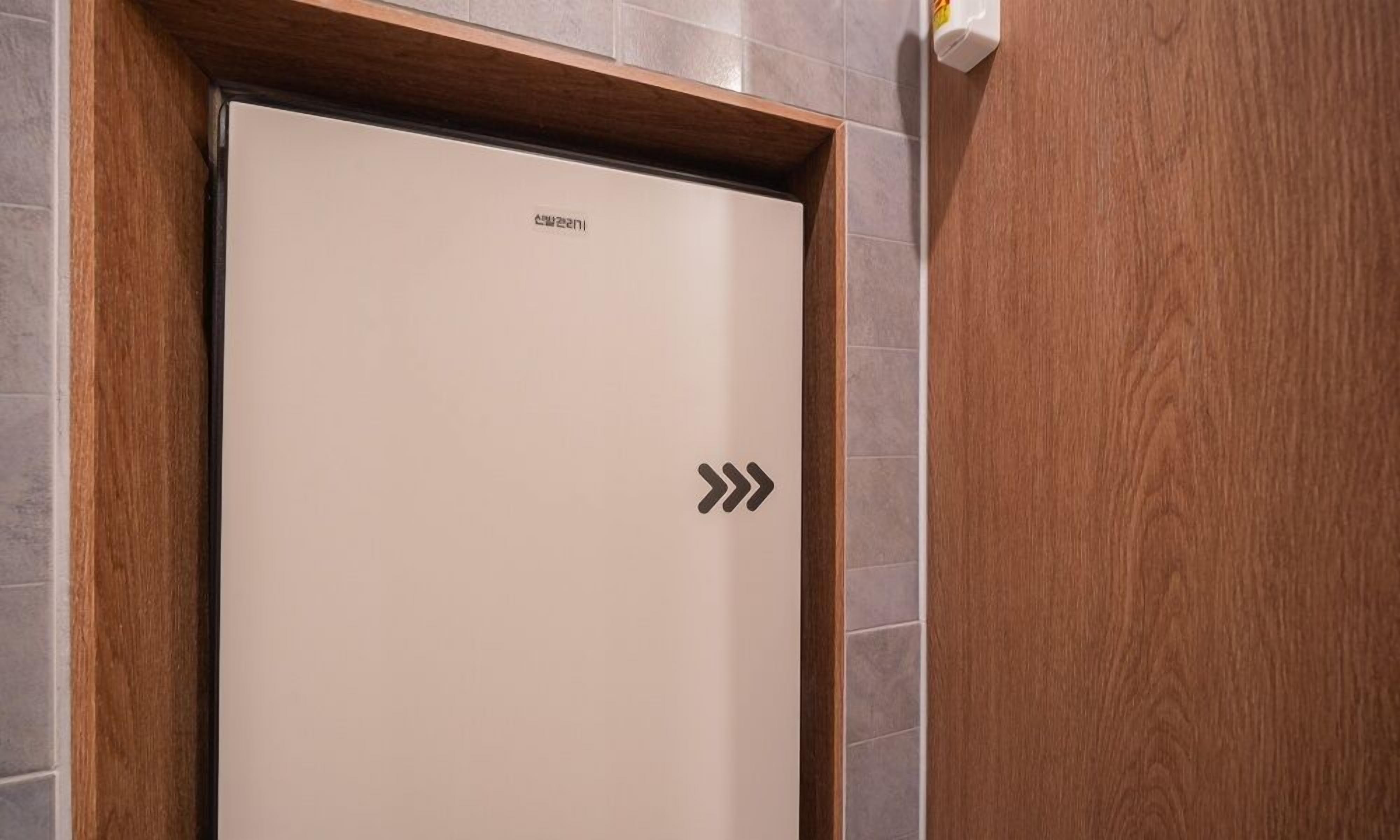 A hotel elevator with a plain interior and a wooden frame.