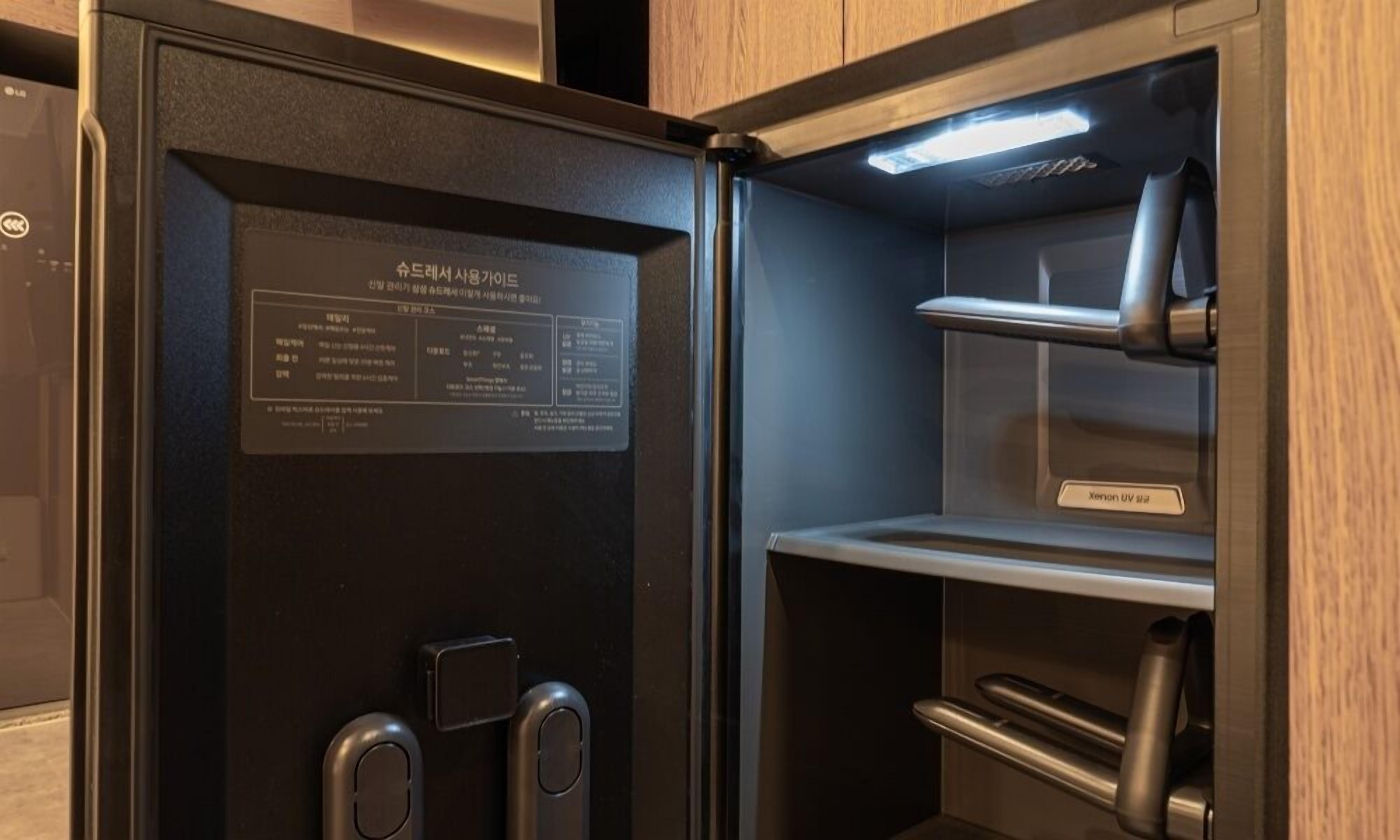 A modern, compact refrigerator with a digital display and a sleek design.