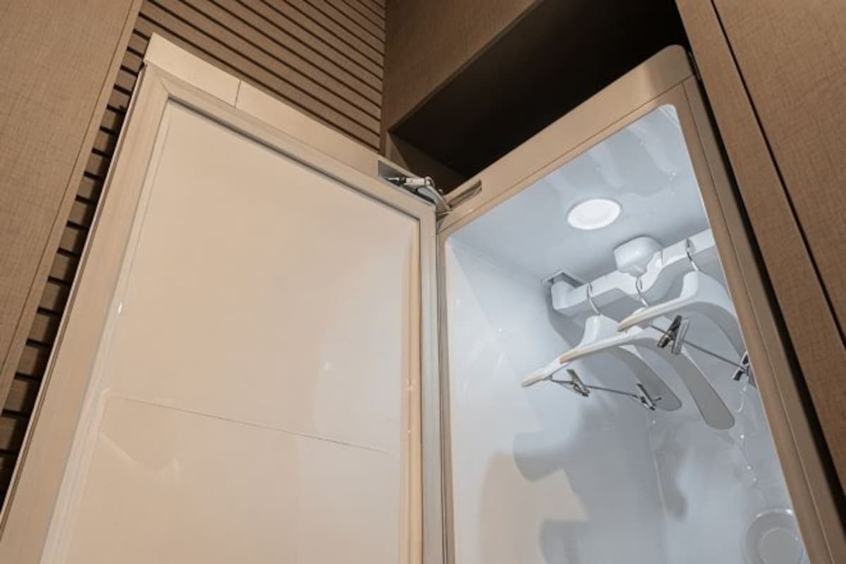 A shower with a glass door and a towel rack.