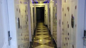 A hotel corridor with mirrored walls and a checkered floor pattern. - Yueyi Hotel (Shanghai)