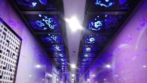 A corridor with illuminated ceiling panels displaying abstract patterns. - Yueyi Hotel (Shanghai)