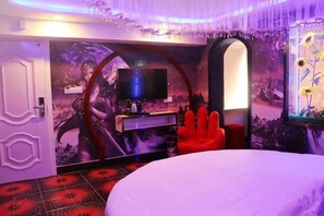A room with a bed, a red chair, a television, and a wall with a floral mural. - Yueyi Hotel (Shanghai)