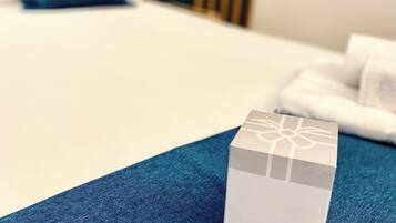 Une boîte de bienvenue posée sur un lit recouvert d’une couverture bleue.