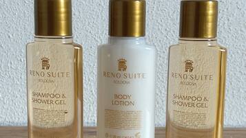 Trois produits de la gamme RENO SUITE : un shampooing et un gel douche, une lotion pour le corps, et un shampooing et un gel douche.