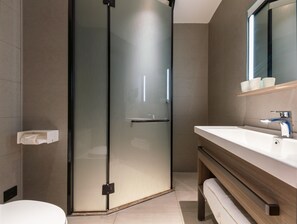 A modern bathroom with a glass shower enclosure, a white sink with a wooden vanity, and a mirror above the sink. - Hanting Hotel Beijing Beiqijia Future Technology C (Beijing)