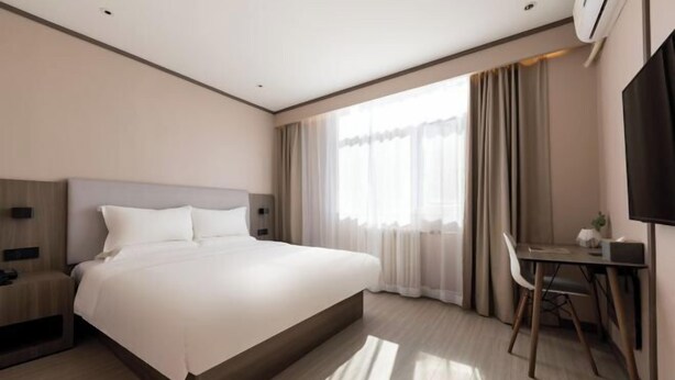 A modern hotel room with a large bed, a desk, and a TV. - Hanting Hotel Beijing Beiqijia Future Technology C (Beijing)