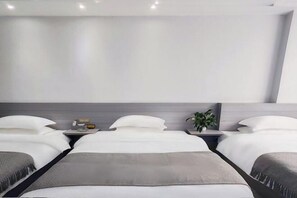 A modern hotel room with a large bed, two bedside tables, and a small plant. - Wudang Mountain Daohe Hotel (Danjiangkou)