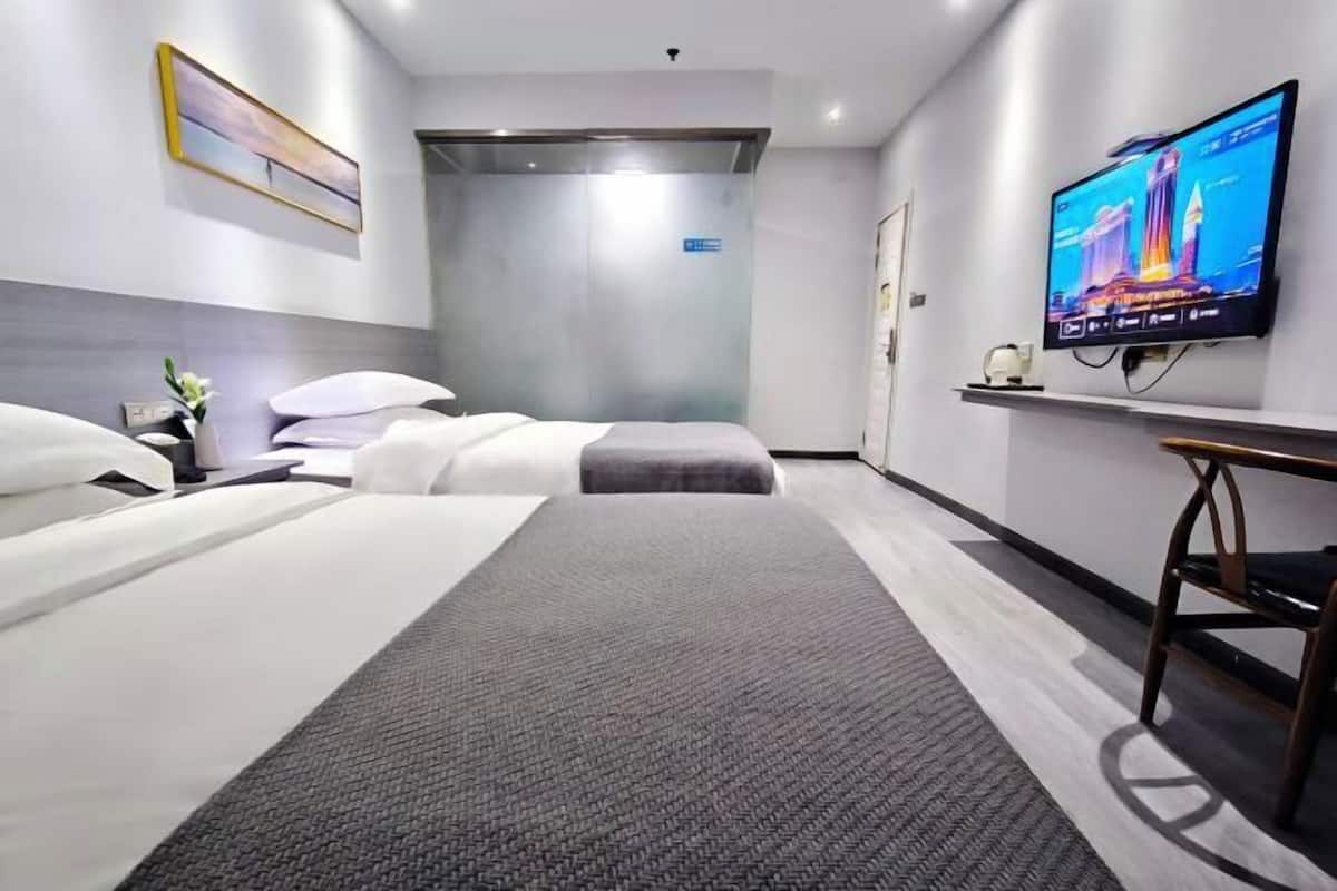 Une chambre d’hôtel avec un lit, un bureau, une télévision et une porte.