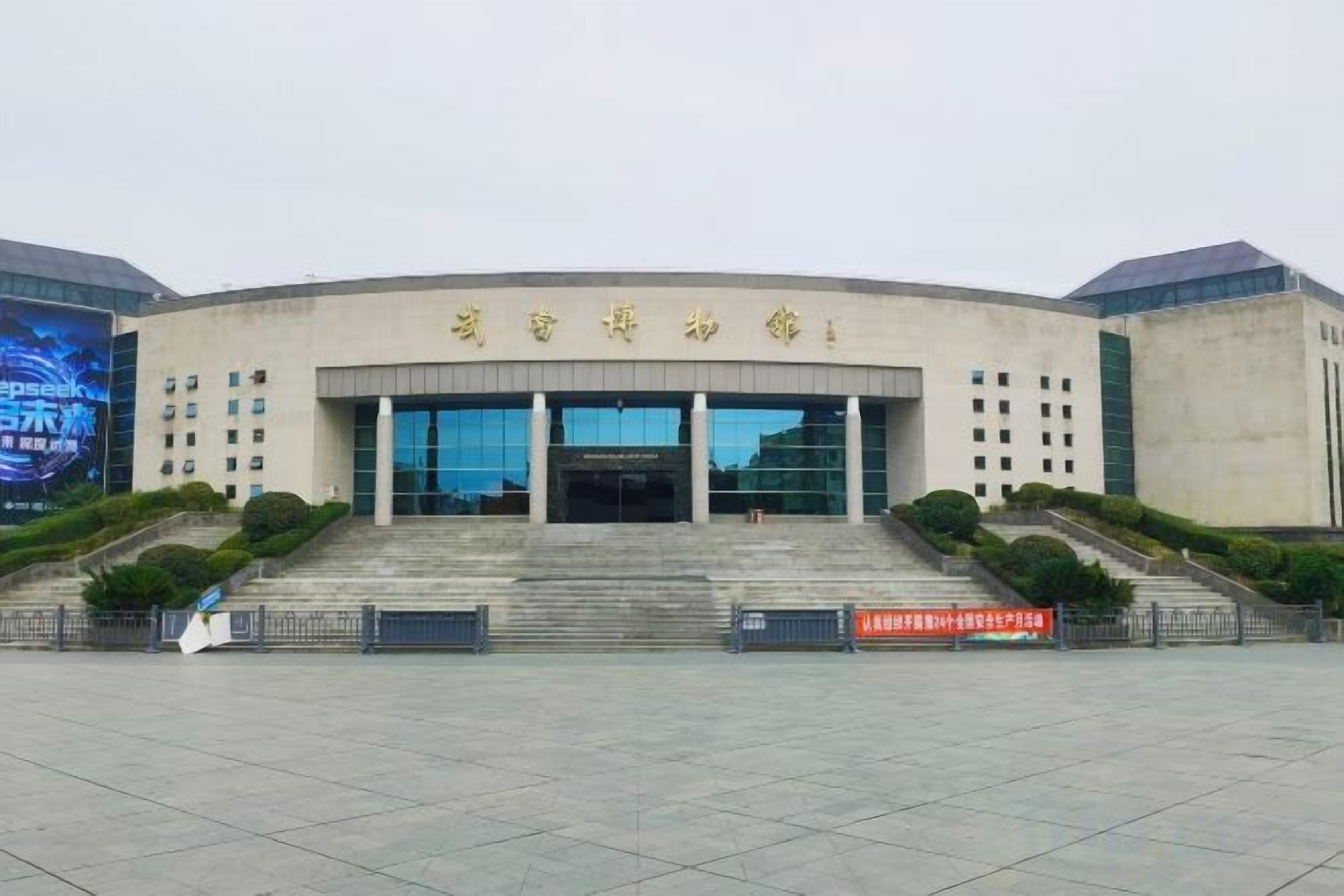 A large, modern building with a curved facade, multiple windows, and a central entrance.