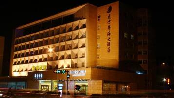 A multi-story hotel with a modern architectural design, featuring a prominent entrance and signage.