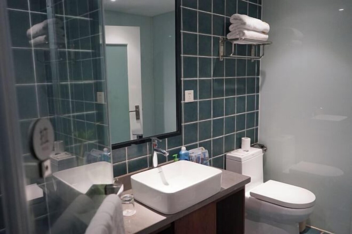 A bathroom with a white sink, a mirror, a towel rack, and a toilet.